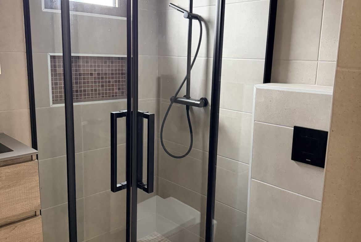 Modern bathroom with walk-in shower at Perseus Living apartment