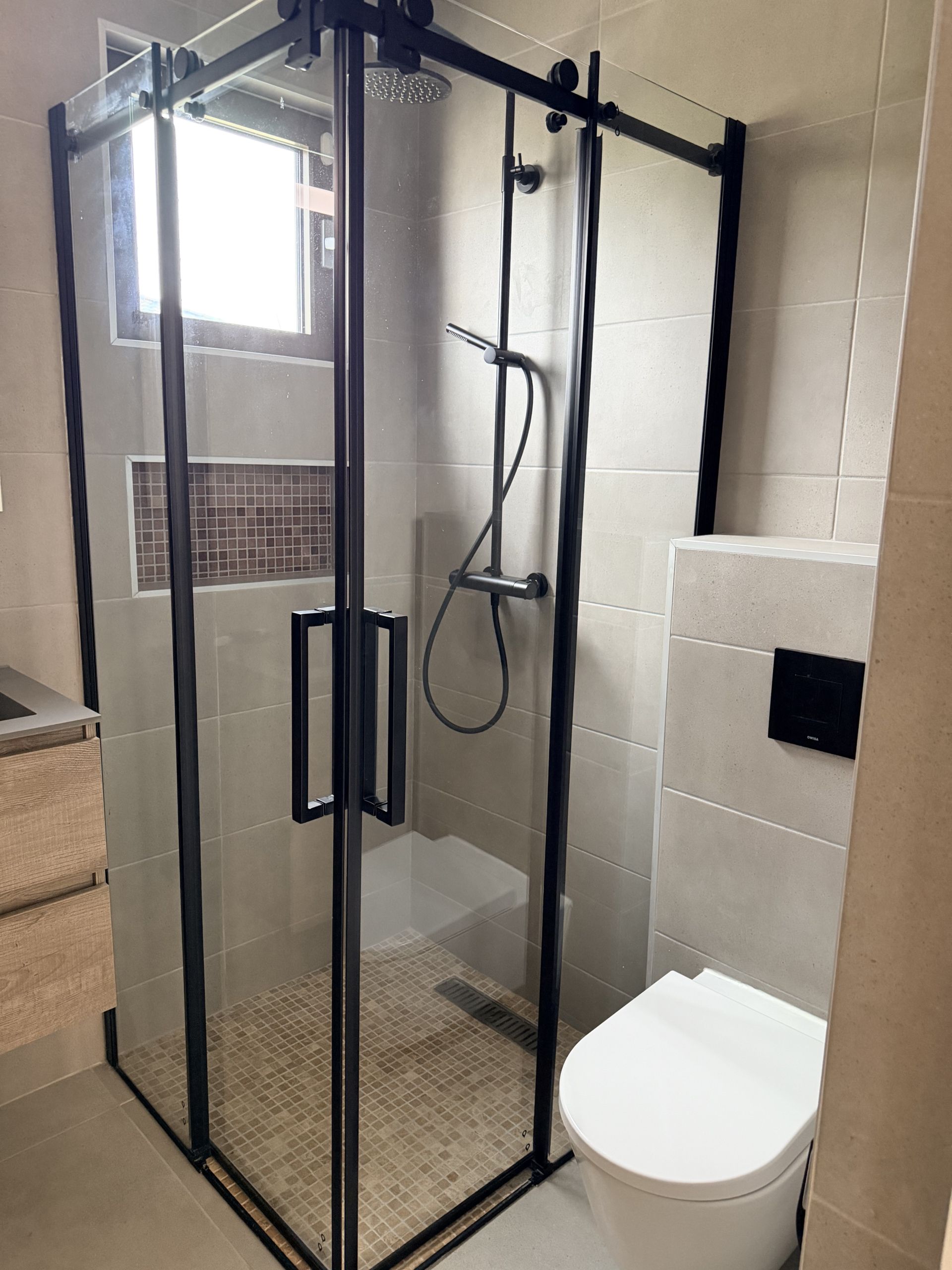 Modern bathroom with walk-in shower at Perseus Living apartment